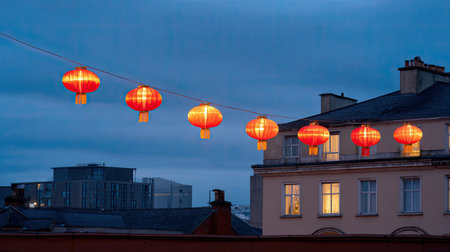 The image showcases vibrant red lanterns elegantly hanging against a dusky evening backdrop, adding a festive touch to urban architecture.の素材