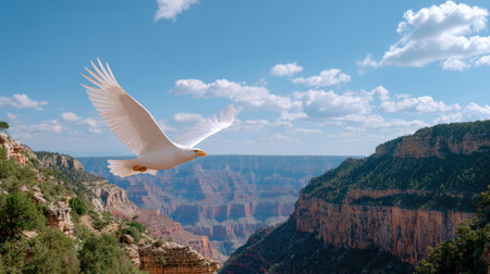 A stunning white bird gracefully glides over the breathtaking Grand Canyon, showcasing nature's splendor under a bright blue sky adorned with fluffy clouds.の素材