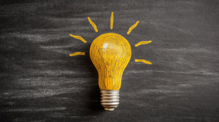 This image features a creatively illustrated light bulb on a black chalkboard, highlighting themes of innovation and inspiration in a visually appealing way.の素材