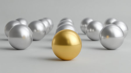 A striking golden sphere emerges among several silver spheres, showcasing contrast and elegance. This visually captivating image symbolizes uniqueness and value.の素材