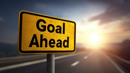 A vivid road sign displays the message "Goal Ahead," set against a stunning sunset background, symbolizing direction and motivation for travelers on their paths.の素材