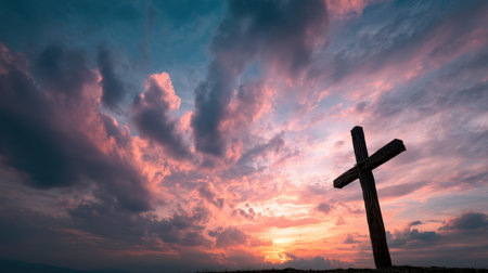A striking silhouette of a wooden cross against a vibrant sunset sky filled with dramatic clouds, evoking feelings of faith, serenity, and spiritual reflection.の素材