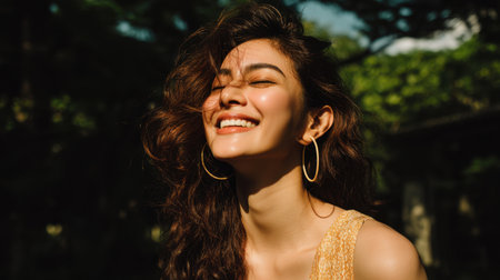 A joyful young woman basks in sunlight, radiating happiness and confidence. Her curly hair and stylish outfit highlight the beauty of outdoor leisure and carefree moments.の素材