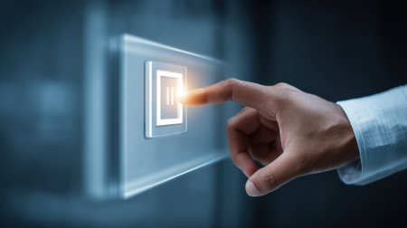 A hand gently pressing a modern illuminated touchscreen button, exemplifying the integration of technology and user experience in innovative digital interactions.の素材