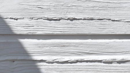 A close-up of textured white wood paneling showing intricate grain patterns and subtle shadows, perfect for design, decor, or architectural projects.の素材