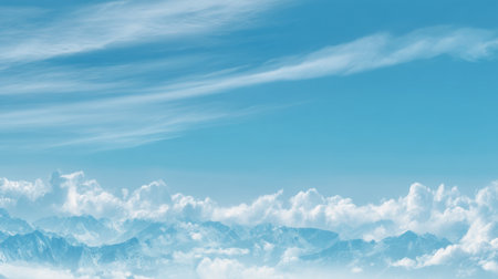 A breathtaking view showcasing the expansive blue sky filled with soft, fluffy clouds over majestic mountain peaks, creating a serene and peaceful landscape.の素材