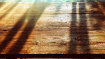 A beautiful wooden table surface illuminated by sunlight filtering through trees. The warm tones and natural textures create a serene outdoor atmosphere perfect for relaxation.の素材