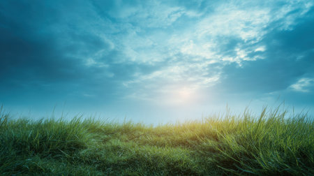 A tranquil landscape showcasing lush green grass under a beautiful blue sky adorned with soft clouds, emphasizing the peacefulness of nature at dusk or dawn.の素材