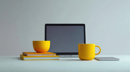 A bright and minimal workspace featuring a sleek laptop, yellow mugs, and stacked books, perfect for creating an inviting atmosphere for work or study.の素材