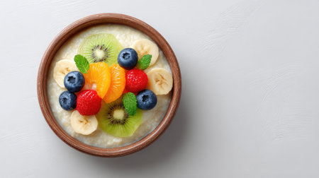 A vibrant breakfast bowl featuring creamy oatmeal topped with a mix of fresh fruits and berries, perfect for a healthy and energizing meal at any time of the day.の素材
