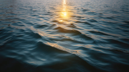 Captivating view of water surface with gentle waves reflecting the golden sunlight at dusk, creating a serene atmosphere perfect for nature and tranquility themes.の素材