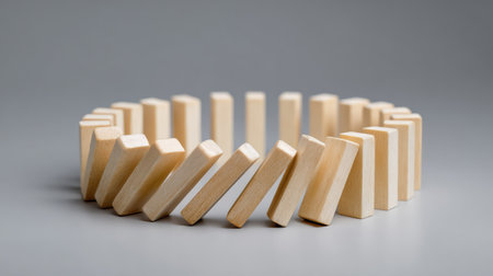 This image showcases a series of wooden dominoes arranged in a circular pattern, symbolizing balance and motion. The neutral background enhances the focus on the creative design.の素材