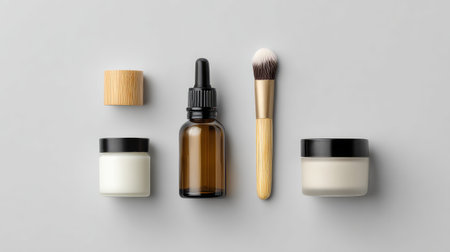 Explore a serene display of skincare essentials including creams, oils, and brushes perfect for any beauty routine on a minimalistic grey background.の素材