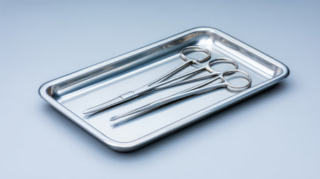 A set of stainless steel surgical instruments displayed on a clean tray, emphasizing the importance of hygiene and precision in medical procedures within healthcare settings.の素材