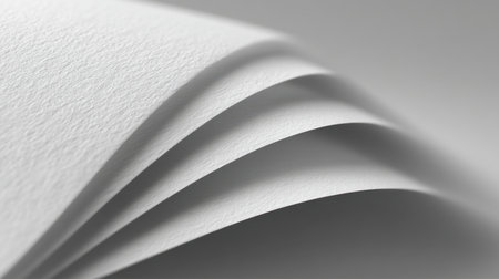 A close-up view of elegant white paper sheets, showcasing their smooth texture and soft curves, ideal for artistic and design projects that require minimalistic elements.の素材