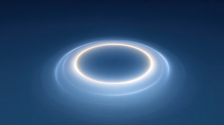 This abstract image features a glowing circle with gentle light effects against a deep blue background, ideal for creative projects, designs, and modern aesthetics.の素材