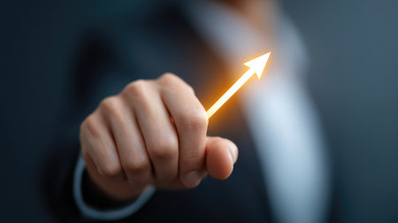 A close-up of a hand pointing upward, signaling growth and success. This image captures the essence of ambition and professionalism in the business world.の素材
