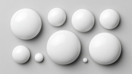 A captivating arrangement of glossy white spheres on a smooth light gray background, offering a modern and minimalist aesthetic perfect for artistic projects and creative designs.の素材