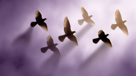 A group of silhouetted birds soaring through soft purple clouds, creating a peaceful and serene atmosphere perfect for nature appreciation and artistic inspiration.の素材