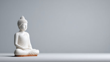 A white Buddha statue set against a smooth gray backdrop, symbolizing peace and tranquility, perfect for themes of meditation, spirituality, and minimalistic design.の素材