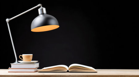 A serene workspace featuring an open book, a stylish lamp, and a coffee cup on a wooden table, perfect for creating an inviting study or work area at home.の素材