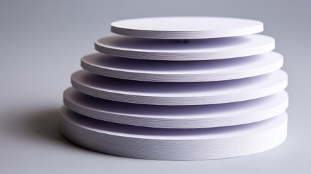 A series of elegantly stacked circular platforms in soft tones, ideal for showcasing products or art pieces in minimalistic design projects with clean lines and subtle textures.の素材