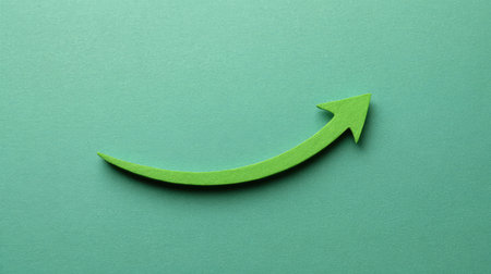 A vibrant green arrow curves upward against a soft mint backdrop, representing growth and positive direction, perfect for business and motivational themes.の素材