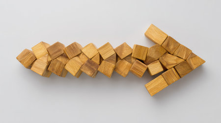 A creative assembly of wooden cubes arranged to form an arrow, symbolizing direction and progress. This image represents innovation and growth in various fields.の素材