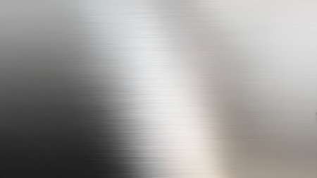 This image features a smooth metallic surface with a gentle gradient that reflects light in soft silver tones, perfect for backgrounds and modern design projects.の素材