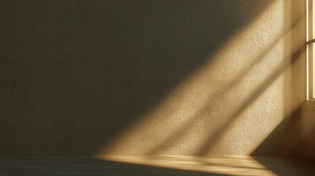 A tranquil view of soft sunlight filtering through a window, casting delicate shadows on a textured wall and illuminating a warm wooden floor in a serene indoor setting.の素材