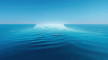 This image captures a vast ocean view, featuring gentle waves beneath a clear blue sky and soft sunlight illuminating the horizon, evoking peace and tranquility.の素材