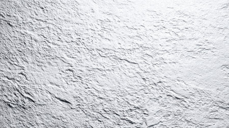 A close-up view of a textured white plaster surface, showcasing natural variations and detailing. This unique background is ideal for design projects and creative solutions.の素材