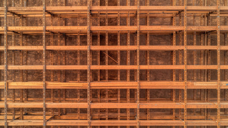 Aerial view of scaffolding beams and metal planks arranged in a symmetrical pattern on a building site.の素材