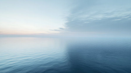 A soft morning sky in shades of pale blue, with a faint glow near the horizon.の素材