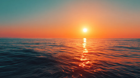Captivating view of a serene sunset over calm ocean waves, showcasing vibrant colors reflecting on the waterの素材