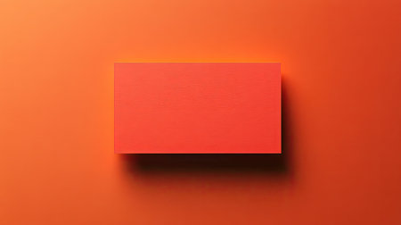 Minimal blank business card on a bold orange background with small geometric cutouts for a modern design.の素材