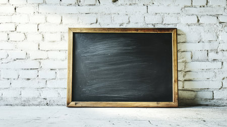 A blank chalkboard sign with a thin wooden border, leaning against a whitewashed brick wall with soft lighting.の素材