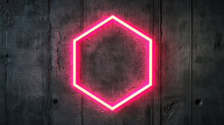 Bright pink neon hexagon glowing on a dark concrete wall with texture.の素材