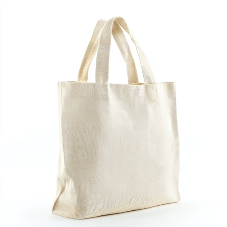 A simple eco-friendly beige fabric tote bag with handles, isolated on a white background, perfect for shopping and sustainability concepts.の素材