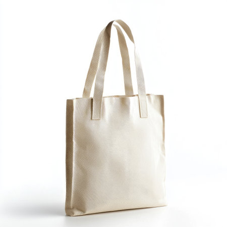 A simple organic cotton tote bag with sturdy handles, isolated on a white background, eco-friendly and reusable for sustainable shopping.の素材