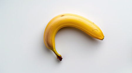 Fresh yellow banana against a plain white background, ideal for healthy eating and nutrition concepts.の素材