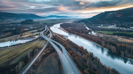 Aerial panorama of a highway overpass intersecting a scenic river valleyの素材