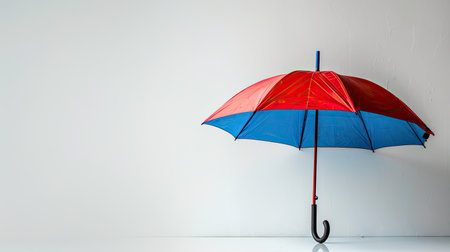Vibrant red and blue umbrella standing out against a white backdrop7d9767bfaa37の素材