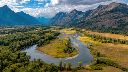 Explore a captivating aerial scene showcasing a river winding through a verdant valley, bordered by towering mountains under a dramatic sky, perfect for nature lovers.の素材