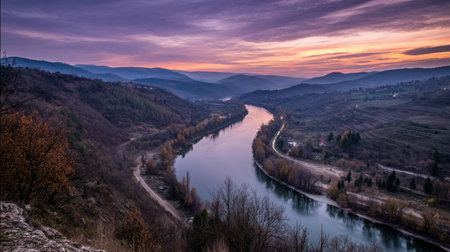 A breathtaking view of a winding river surrounded by hills at sunset, showcasing vibrant colors in the sky and calm water reflections, highlighting nature's serene beauty.の素材