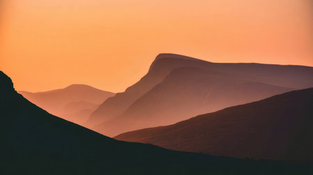 Captivating mountain landscape during dusk, featuring softly layered peaks under a warm sunset sky. The tranquil beauty evokes a sense of peace and exploration.の素材