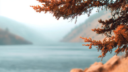 A tranquil autumn scene featuring vibrant orange foliage over calm water, surrounded by gentle hills. Perfect for evoking themes of peace and nature's beauty.の素材