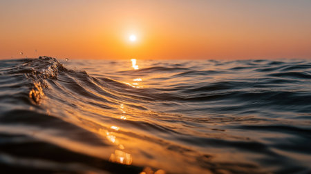 A breathtaking view of a serene sunset over calm ocean waves, showcasing the warm colors of dusk while the water reflects the soft sunlight in a peaceful manner.の素材