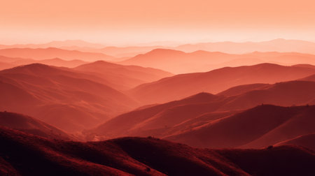 A breathtaking view of rolling hills bathed in warm hues during sunrise. The misty mountains create a serene and tranquil atmosphere perfect for nature lovers.の素材