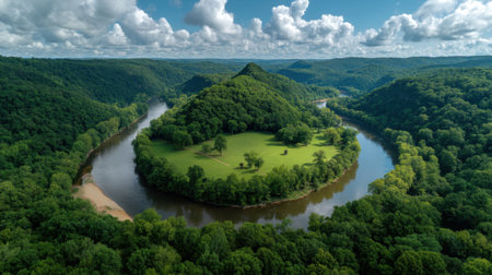 Experience a breathtaking aerial view of a lush green landscape with a winding river and rolling hills under a vibrant blue sky dotted with clouds.の素材